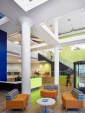 The two-story main entry lobby includes lounge spaces, a security check-in station, and vertical circulation.
