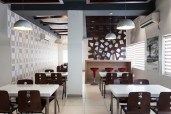 Situated in an old warehouse, the café uses salvaged materials and furniture to minimize costs