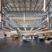 A stair linking the Crib to the floor below is supported on a single box girder that appears to peel down from the Crib?s floor system. The stair itself is a series of welded, bent steel plates, bracketed by a stainless steel railing and draped with steel mesh. Interior staircases lead from the studio level to offices and galleries above.