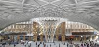 The glass, steel, and aluminum diagrid roof of the new Western Concourse at King?s Cross station spans out from a central woven funnel.