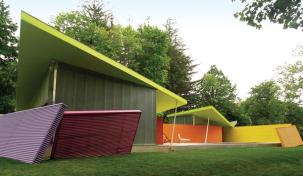 Stamberg Aferiat Architecture used painted corrugated aluminum for the canted accessory walls and multipaneled polycarbonate for the building's walls. A rubber butterfly roof tops the structure.