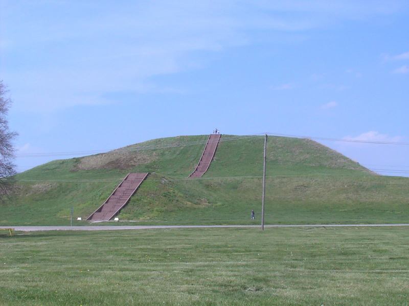 Monk's Mound, created by the Mississippian culture, is located at Cahokia. The staircase you see is new, but built to follow the course of the original wooden stairs. Also visible is a road and power lines cutting through the site.