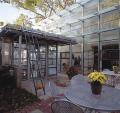 An old bakery conveyor belt undulates above the indoor tables (middle), concealing inexpensive light fixtures. Translucent glass awnings (top) add texture to the rear of the house.