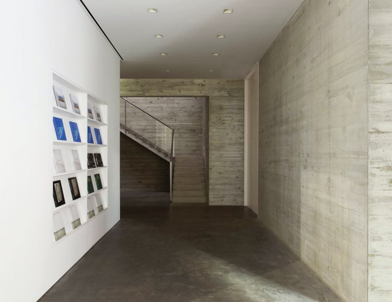 White walls for mounting artwork contrast with the stark concrete floors and walls.