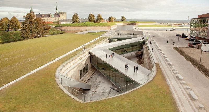 The subterranean museum surrounds a former dry dock less than 1,000 feet from Kronborg Castle (back left), a protected UNESCO heritage site.