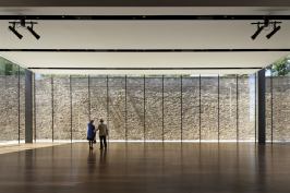A former prison wall serves as a rugged backdrop for the streamlined events space.