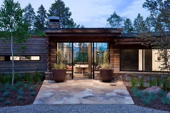 Exterior, horizontal, front entry at twilight looking into living room and view out windows to mountains and forest, Rosenthal residence, Wilson, Wyoming; Ward + Blake Architects
