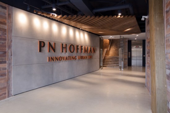 The multi-faceted lobby introduces the office’s design intent– reflect the area’s rich history, the beauty found in the simplicity of building, and PN Hoffman’s entrepreneurial journey from local developer to prestigious shaper of cityscapes. Wingate Hughes accomplishes this with elegantly executed elements like the sheeting and shoring-lined lobby, commonly used when installing the foundation of a building or on a vessel, and the custom angled, multi-ribbed wood-slat ceiling reminiscent of the underbelly of a ship.