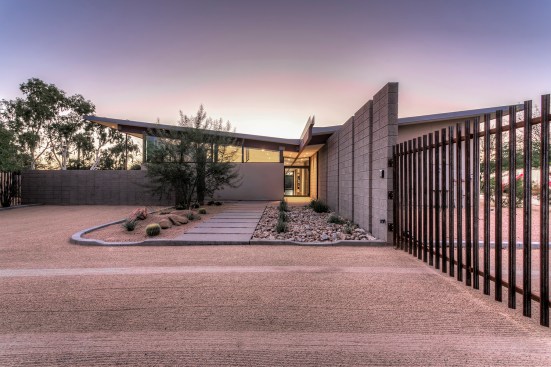 Front entry of home.  The low point of the butterfly roof is centered over the front entry door.  An 
exposed beam connects the roof and creates an organizing element inside and outside the home.  This 
exposed beam defines the interior circulation path of home. 