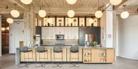 New kitchen with large island and custom steel & glass backlit upper shelves.