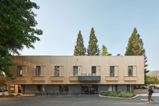 The design is a study in layers, using a language of vertical wood boards and protruding window volumes