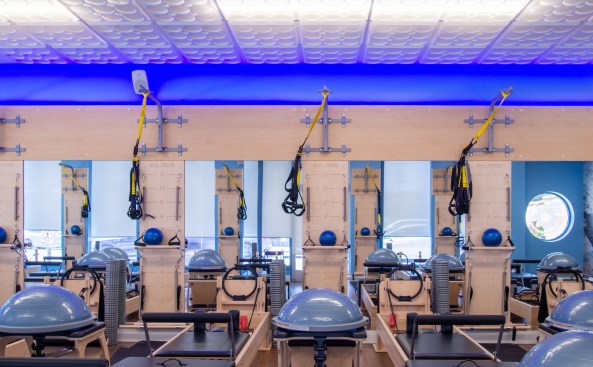 A chain of Club Pilates exercise studios in Southern California have created a signature décor built around a
Ceilume decorative thermoformed ceiling with a blue glow lighting up the edge.