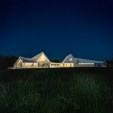 A series of barn roofs connect and contort to cover the program. The building overlooks the 'Hillside Meadow'