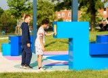 Two local kids from the community who helped design the space play with the installation.