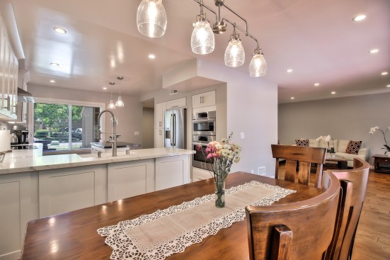 White shaker cabinet, Open space kitchen with quartz counter top. 
Wood flooring 