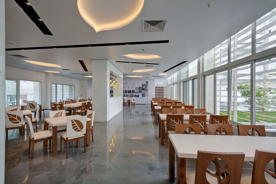 Dining area of 100 capacity is designed in such a way that it gets view of the neighboring golf course on one side  & courtyard on the other. The dining area has pattern of leaves starting in the ceiling which continues in the chairs. Every piece of furniture is designed with detailing so that at no point, the theme of the project is lost.  
