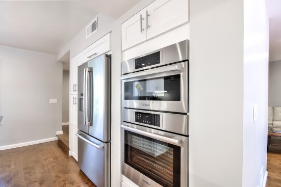 White shaker cabinet, Open space kitchen with quartz counter top. 
Wood flooring 