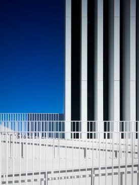 The overlapping handrails are simply a smaller scale of the building façade.   