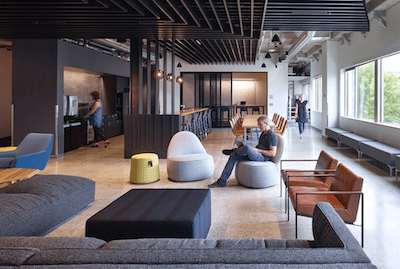 Open workspaces contain living room setups with sofas, lounge chairs and large TVs for game testing.