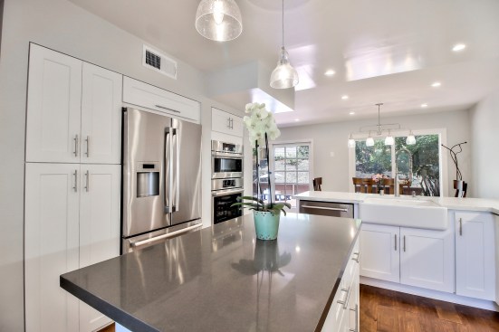 White shaker cabinet, Open space kitchen with quartz counter top. 
Wood flooring 