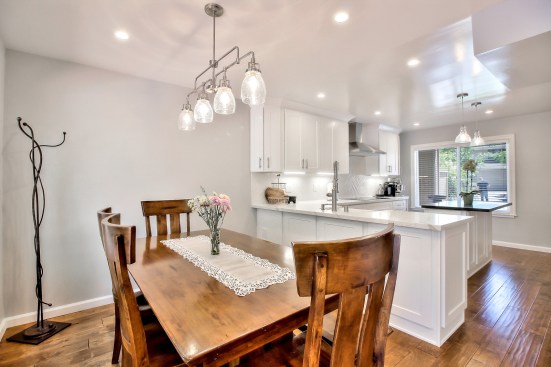 White shaker cabinet, Open space kitchen with quartz counter top. 
Wood flooring 
