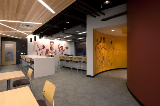 The men’s basketball player’s lounge comes to life with full-wall graphics of current players in
splashes of maroon and gold.