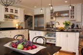 This farmhouse had received several updates and renova-
tions over the years. However, the floor plan was conflict-
ing amongst the kitchen, laundry, mudroom, and powder 
room. A complete reorganization of the first floor was 
achieved through multiple structural changes that al-
lowed for a larger kitchen and created better flow be-
tween adjacent rooms. The kitchen includes custom 
painted cabinetry, a farmhouse style sink, and soapstone 
countertops. A commercial size Viking range, hood, and 
Sub Zero refrigerator bring a theme of stainless steel to 
the kitchen which is accentuated by brushed nickel hard-
ware and island faucet. Specialty lighting, glass door 
cabinets, and a grand, eight foot island are just a few of 
the features that make this kitchen stunning.