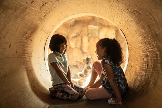  Two girls play in one of the Tree House structures.