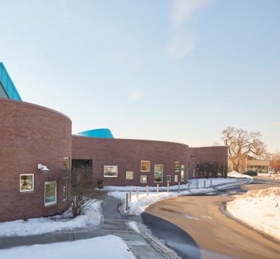 The center's curving walls vary in height, rising higher over the library section of the building