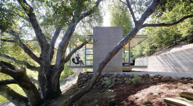 Earthbound concrete towers let the transparent boxes perch delicately above the site.
