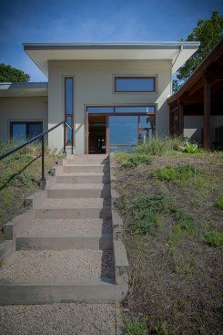 Stairs lead from the meadow to the deck above.