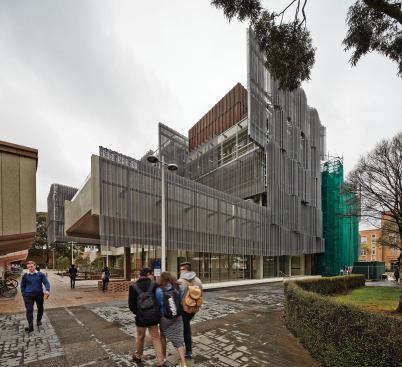 A historic masonry façade, gifted to the school in 1932, is still under the green scaffolding in the distance as the installation completes. The pre-weathered zinc panels from VMZinc and the metal rainscreens and louvers from Fabmetal that clad this portion of the new building will provide a material contrast.