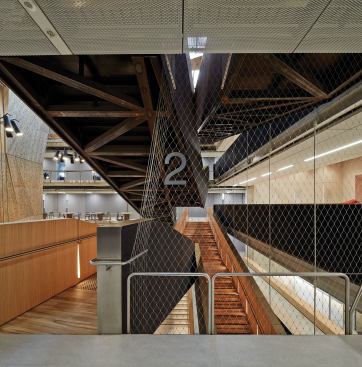 Each level on the stair is noted by a floor number attached to the metal mesh that lines the walls of the atrium.