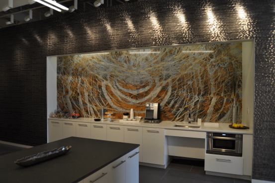 A solid slab backsplash steals the show in a kitchen vignette within the gallery.