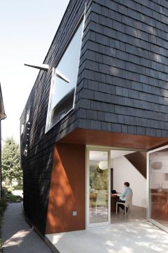 The western wall cants away from the adjacent house at a 6-degree angle to allow natural light into the neighbor's living spaces.