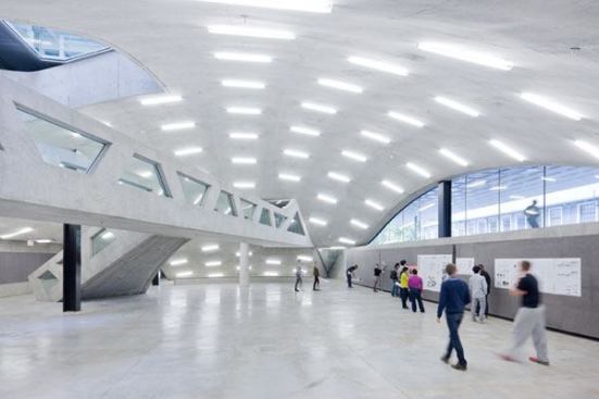 The pedestrian plaza “bump” above created a domed critique space inside the building. Fluorescent striplights cast into the concrete ceiling provide bright, shadow-free ambient lighting and balance with the available natural light.