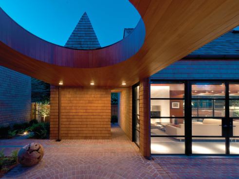 Familiar forms, such as the bath volume&iacute;s steeply pitched roof, eschew overhangs and gutters.