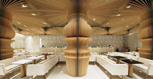 The+space+is+anchored+by+a+series+of+columns+clad+in+plywood+slats+that+are+CNC-routed+to+emulate+a+lathe-turned+table+leg.+