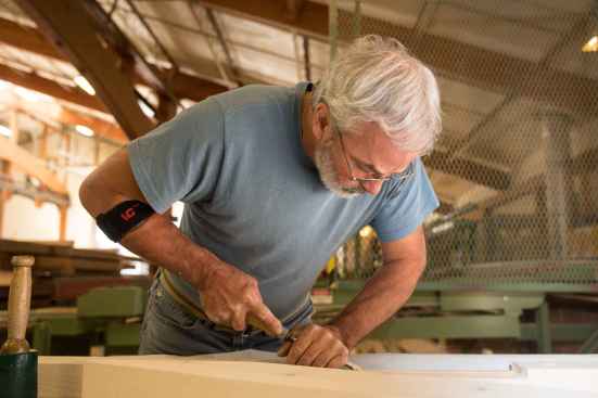 Timberframer Rick Whitcomb hand details part of the 2015 Greenbuild Unity Home roofing structure, at Unity’s Walpole, N.H., factory.
