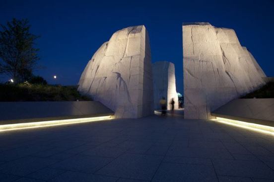 The forecourt entry at night. White-light LED  fixtures line the underside of the concealed cove that illuminates the walkway.