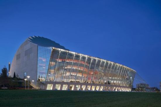 A view of the Kauffman Center for the Performing Arts at night. The lobby area, known as the Brandmeyer Great Hall is seen through the 330-foot-long glass curtain wall.