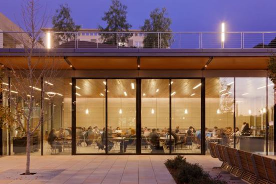 In the café, 2W LED striplights graze the back terracotta wall. Staggered-spaced 32W T8 lensed fluorescent fixtures are located in the wood ceiling, and glass pendants with a 26W triple-tube compact fluorescent lamp provide a decorative accent to the space.