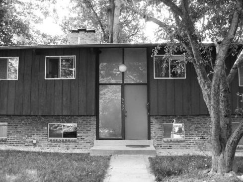 Before: The home’s fa&ccedil;ade showed its age from the globe porch light to the painted wood siding.