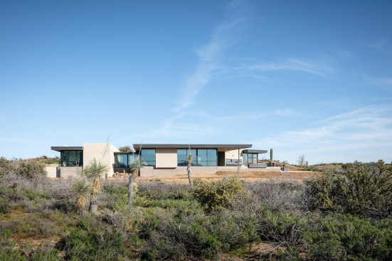 West view of the home.  Exterior, motorized shade panels are hidden in the roof soffit above allowing an unencumbered view of the mountains beyond.
