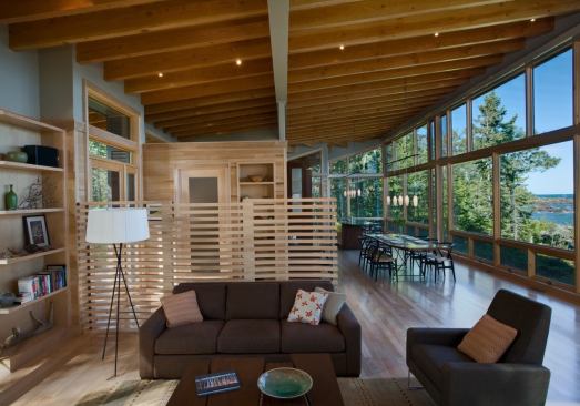 The house’s main living space constitutes a lakefront viewing platform. A wood screen defines a separate space at the entry.