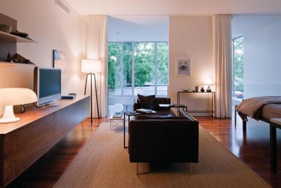 Walnut floors on the second level supply a warm hue to balance the coolness of the glass and plaster.