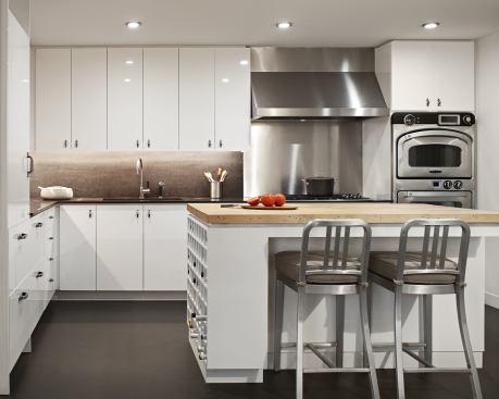 A kitchen island with plenty of room for wine storage is at the center of a duplex apartment kitchen designed for clutter-free living and easy entertaining. Location: New York, N.Y. Architect: Deborah Berke & Partners. Builder: Sweeney + Conroy.