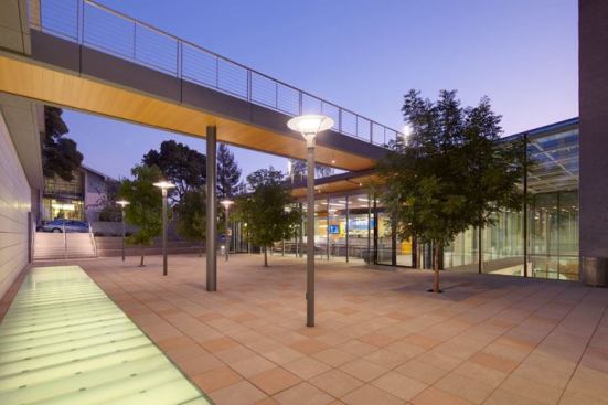 In the plaza area adjacent to the new building’s entrance, pole mounted luminaires with 70W T6 metal halide sources coordinate with the spacing of the trees. The stairs use an LED-illuminated handrail. The frosted glass light wells are backlit with accessible dimmable fluorescents.