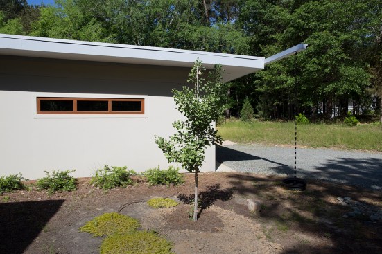A cantilevered gutter and rain chain direct rain water from the garage roof to the landscape.