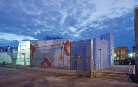Dusk view of the greenhouse, kitchen classroom, and sheds.